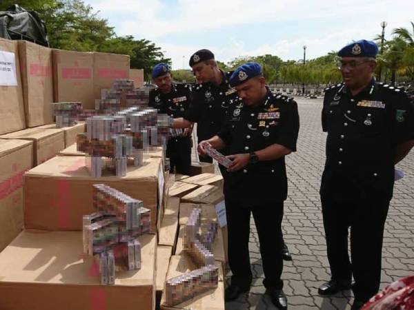 Mohd Yusoff (kiri) melihat rokok tidak sah yang berjaya dirampas Pasukan Polis Marin (PPM) Wilayah Dua Johor awal pagi tadi.