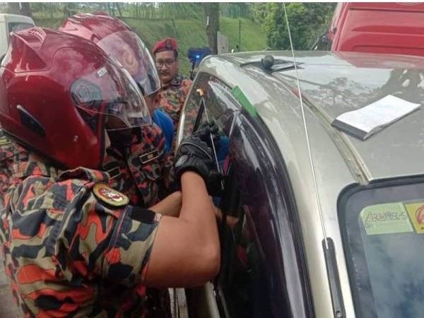 Anggota bomba menggunakan perlatan khas bagi membantu mengeluarkan kanak-kanak yang terperangkap dalam sebuah MPV di Taman Dahlia di sini pagi tadi.