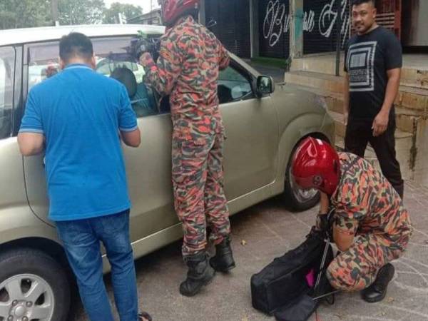 Anggota bomba menggunakan perlatan khas bagi membantu mengeluarkan kanak- kanak yang terperangkap dalam sebuah MPV di Taman Dahlia di sini pagi tadi.
