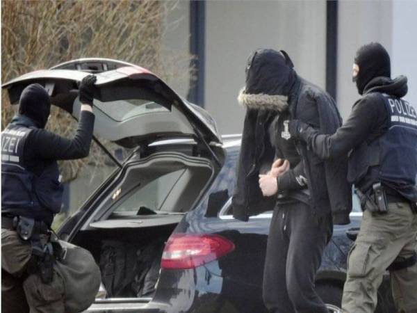 Pegawai polis menahan salah seorang daripada 12 lelaki dalam satu siaatan di seluruh negara. - Foto AFP