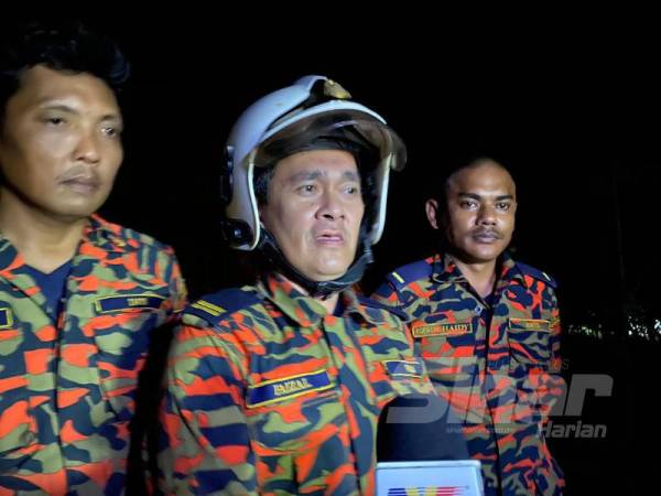 Mohd Faizal (tengah) ketika ditemui di lokasi kebakaran. 