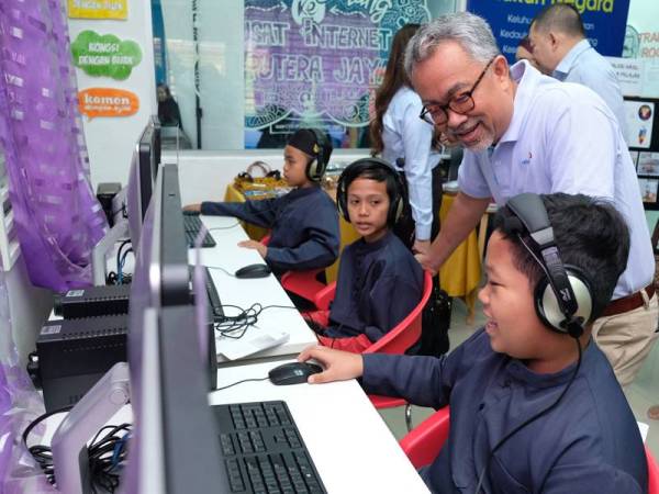 Idham beramah mesra dengan kanak-kanak yang menggunakan perkhimatan internet di Pusat Internet Kampung Telipok, Sabah.