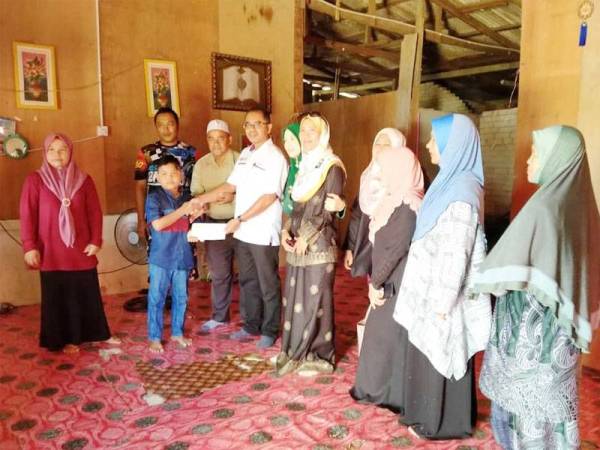 Sansudin menyampaikan sumbangan kepada Wan Muhammad Alhakim.