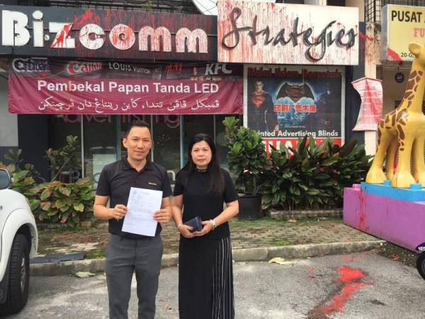 Andy menunjukkan laporan polis yang dibuat selepas kedainy disimbah cat merah.