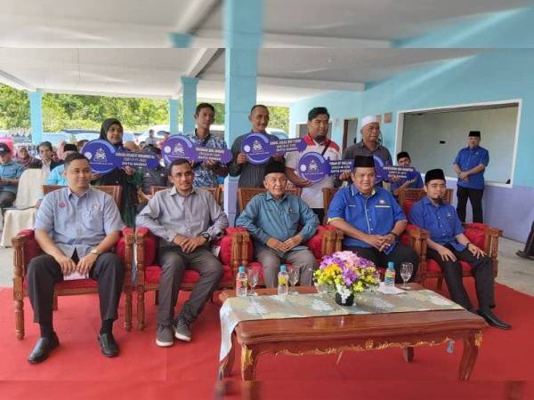 Tosrin (tengah, duduk) bergambar bersama penerima kunci rumah transit Baitul Rahmah, Kampung Tenglu.
