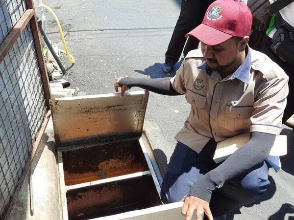 Pegawai MBPP sedang memeriksa sisa bahan masakan (minyak) di restoran nasi kandar dalam operasi tadi.