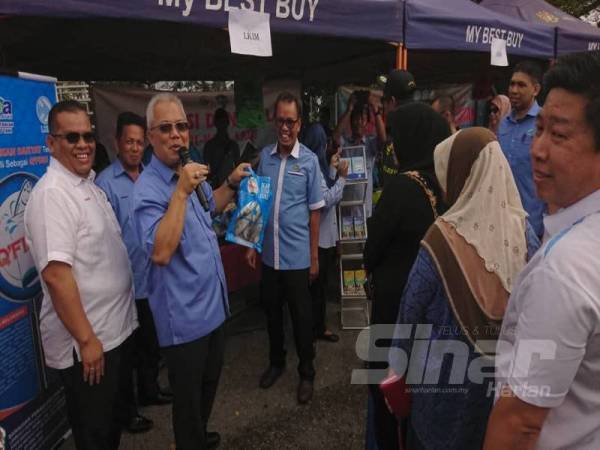 Ishak kiri mengumumkan harga promosi ikan sejuk beku LKIM ketika lawatan ke gerai jualan pada program itu. 
