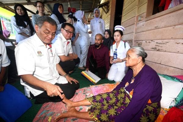 Dr Dzulkefly (kiri) bertanya kepada Jahiran Isnani, 63, yang sakit kaki dan tekanan darah tinggi sewaktu melawat warga emas itu sempena program Jelajah Kampungku Sihat di Kampung Kabogan hari ini. -Foto Bernama
