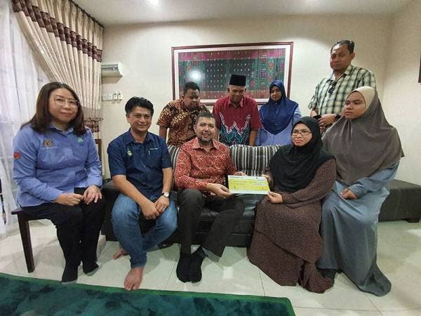 Marzuki menyampaikan replika cek faedah pencen penakat kepada Norwani.