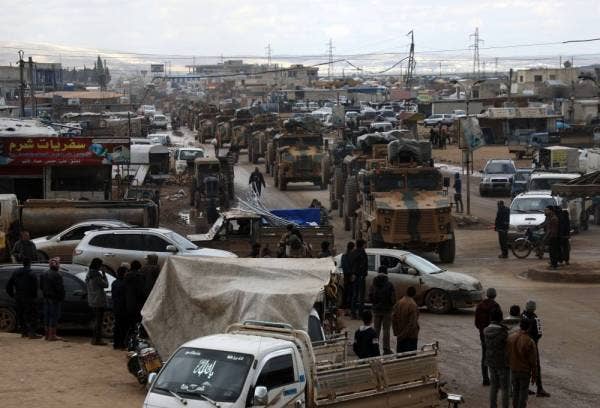 Penduduk melihat konvoi ketenteraan Turki ketika mereka melintasi bandar hazano di wilayah Idlib, Syria semalam. - Foto AFP
