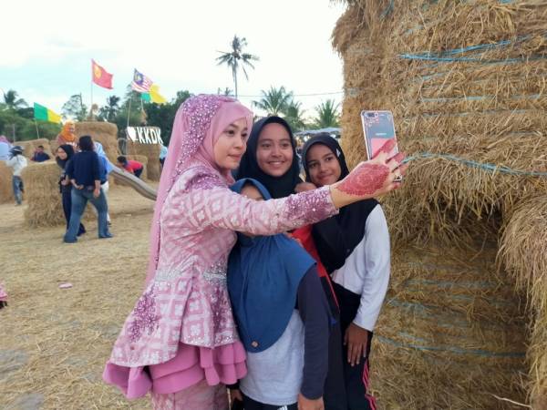 
Wan Hasrina berswafoto bersama ahli keluarganya di samping jerami gulung.