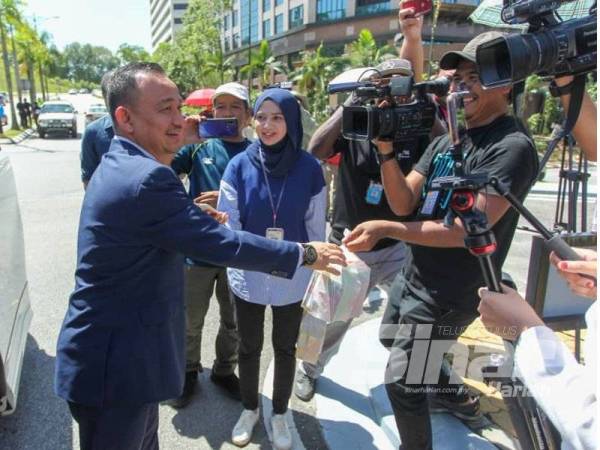 Maszlee memberhentikan kenderaan dan memberikan minuman kepada petugas media. - FOTO SHARIFUDIN ABDUL RAHIM