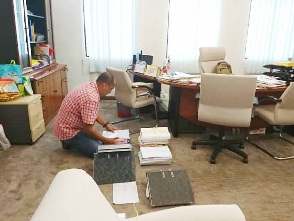 Seorang kakitangan sedang mengemas barang di pejabat Exco Kesihatan dan Anti Dadah, Low Chee Leong.