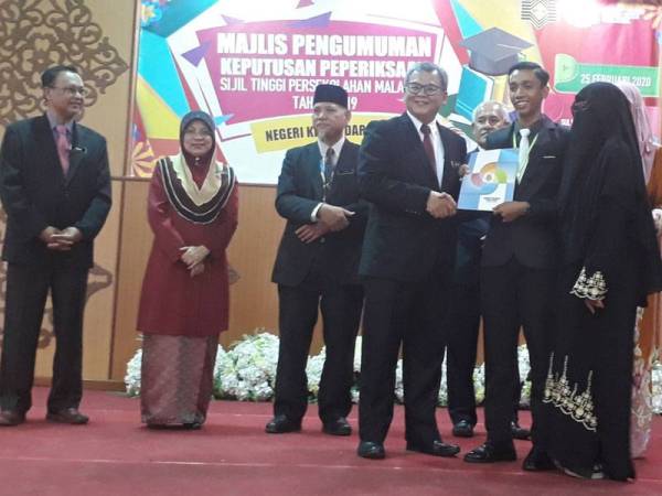 Muhammad Maqamin Amin (tiga dari kanan) menerima sijil penghargaan daripada Abd Aziz di Kolej Tingkatan Enam Sultan Sallehuddin Alor Setar hari ini.