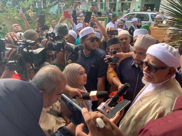 Abdul Hadi (kanan) menjawab soalan media selepas menyampaikan kuliah dhuha di Masjid Rusila, hari ini.