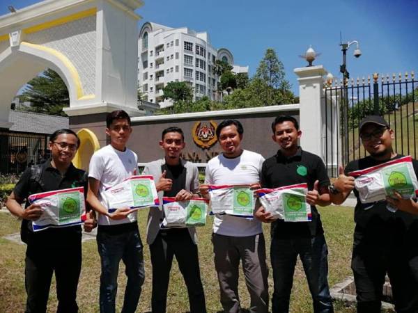 Mohd Fahmi (tiga dari kiri) dan kakitangan MatJenin.my mengedarkan sebanyak 100 pek makanan kepada petugas media yang membuat liputan di Istana Negara semalam.