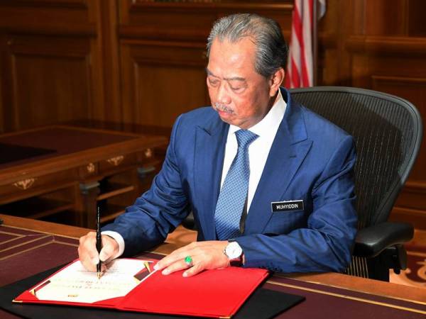 Perdana Menteri Tan Sri Muhyiddin Yassin menandatangani buku selamat datang dan selamat bertugas di Perdana Putra hari ini.
- Foto Bernama