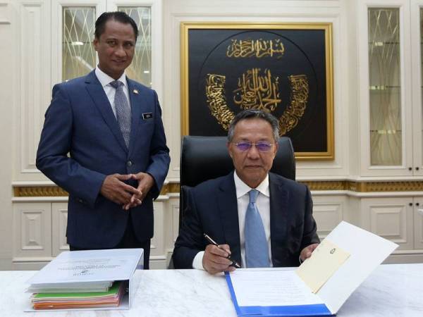 Hasni (duduk) memulakan tugasnya secara rasmi di Pejabat Menteri Besar, Bangunan Dato' Jaafar Muhammad semalam. - Foto Bernama