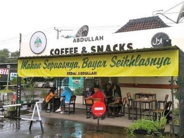 Kain rentang tertera 'makan sepuasnya, bayar seikhlasnya' menarik perhatian ramai. - Foto: Tribun News