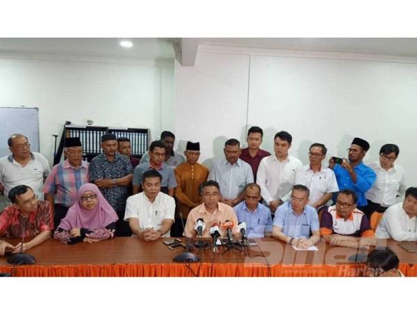 Adly (tengah) dan Kok Kiew (duduk, dua dari kiri) pada sidang akhbar di Ibu pejabat Amanah di Bukit Katil di sini hari ini.