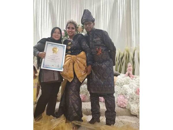 Siti Zakiah bersama pasangan pengantin yang memakai busana songket Melayu dihiasi reben terpanjang hasil rekaannya hingga mendapat pengiktirafan Malaysia Book Of Records.