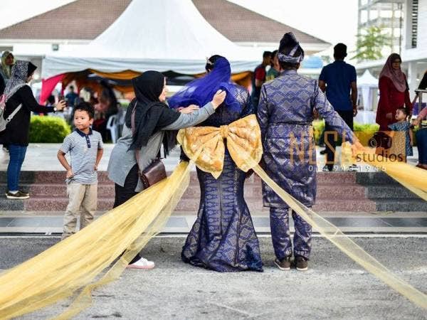 Siti Zakiah bersama mempelai yang memakai reben terpanjang 407.75 meter. - Foto NSH Studios