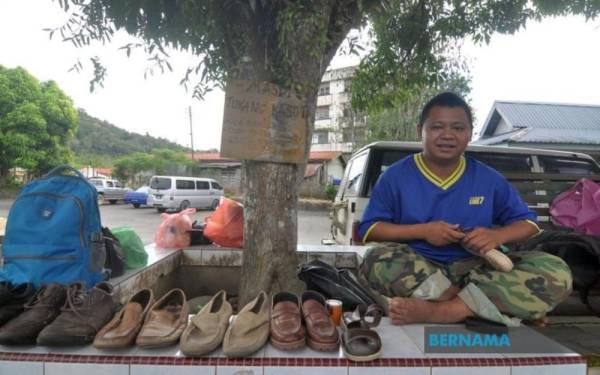 
Masdi menyediakan khidmat membaiki kasut di bawah pokok di Pekan Kiulu, Tamparuli.