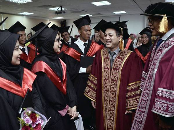 Ketua Setiausaha Kementerian Sumber Manusia Datuk Amir Omar (dua, kanan) bersama Pengarah Urusan dan Rakan Operasi Tempatan McDonald's Malaysia Azmir Jaafar (kanan) beramah mesra bersama sebahagian graduan pada Majlis Konvokesyen Pertama Akademi Vokasional McDonald's Malaysia hari ini. - Foto Bernama