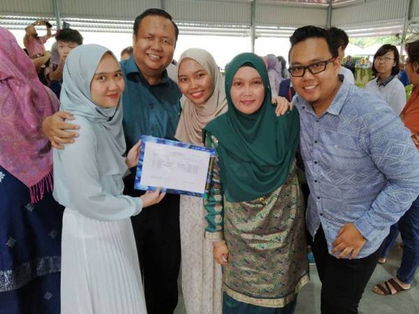 Raudhatunnadiah (tengah) yang mendapat 9A+ bergambar bersama keluarga pada majlis pengumuman keputusan SPM peringkat negeri Johor di SMK Mutiara Rini di sini hari ini.