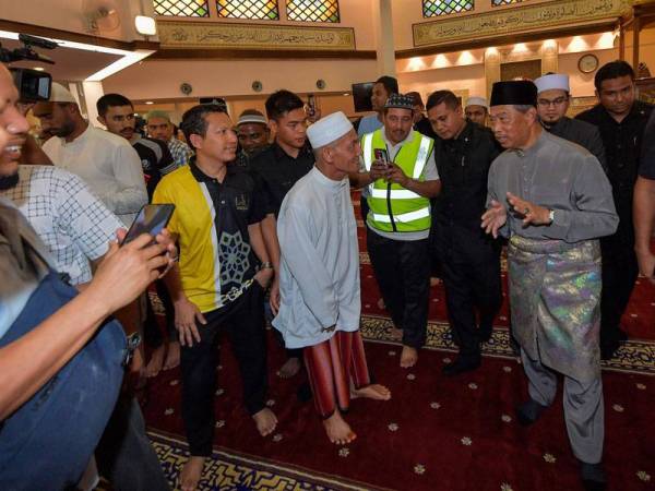 Perdana Menteri Tan Sri Muhyiddin Yassin dilihat berbual bersama para jemaah selepas menunaikan solat Jumaat di Masjid Saidina Umar Al-Khattab, Bukit Damansara hari ini. - Foto Bernama