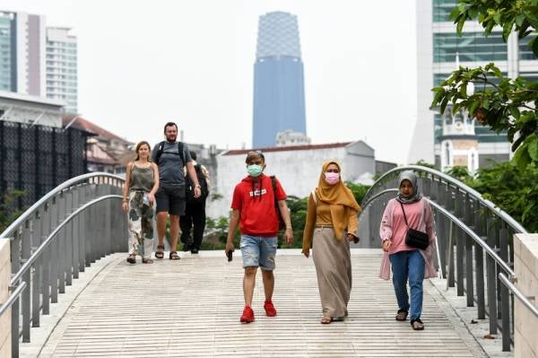 Orang ramai bersiar-siar di sekitar ibu kota dengan memakai penutup hidung dan mulut sebagai langkah berjaga-jaga berikutan penularan jangkitan Covid-19 ketika tinjauan semalam. -Foto Bernama