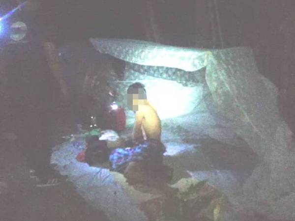 Anggota AADK Besut memeriksa lelaki yang ditemui tinggal dalam kelambu belakang rumah dalam Operasi Cegah.