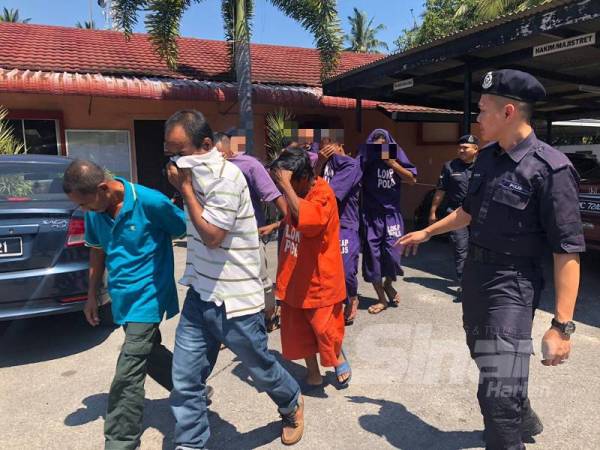 Mohd Shukri (kiri), Raja Deraman dan Abdullah dikawal polis keluar dari Mahkamah Majistret Bachok selepas selesai didakwa atas tuduhan yang dihadapi masing-masing.