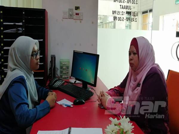 Rina (kanan) mendapatkan maklumat perkhidmatan JKM daeripada kakitangan yang bertugas di kaunter perkhidmatan JKM Sepang pagi ini.
