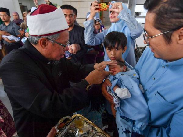Zulkifli menyempurnakan majlis tahnik di Masjid Tuanku Mizan Zainal Abidin hari ini.  - Foto Bernama