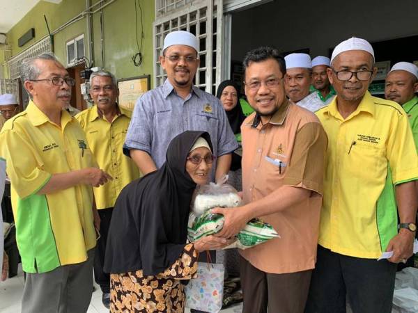 Che Abdullah menyampaikan sumbangan kepada salah seorang penerima di sini.