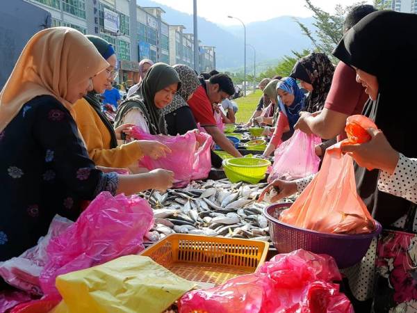 Orang ramai tidak melepaskan peluang membeli ikan kembung yang dibawa dari Kuala Muda, Kedah dan dijual semurah RM10 bagi tiga kilogram di Bandar Meru Raya dan beberapa lokasi di sekitar Ipoh kelmarin. - Foto Bernama