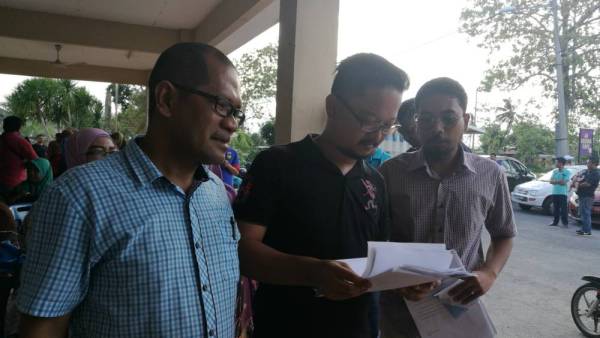 Izhar (kiri) mengumpulkan borang keluar parti.