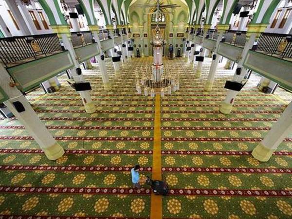 Pekerja pembersihan melakukan pembersihan menyeluruh di ruang solat utama di Masjid Sultan, Singapura. - Foto MUIS