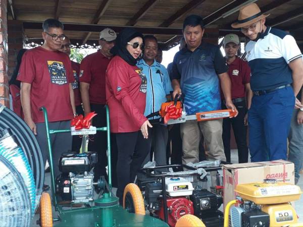 Muhammad Huzaifah (dua dari kanan) menerima peralatan daripada kementerian yang akan digunakan untuk mengembangkan tanaman harumanisnya.