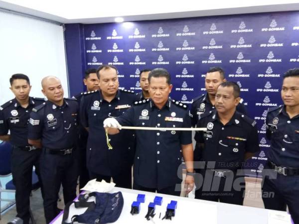 Arifai menunjukkan rotan yang dipercayaidigunakan suspek untuk mendera kanak-kanak berusia enam tahun.