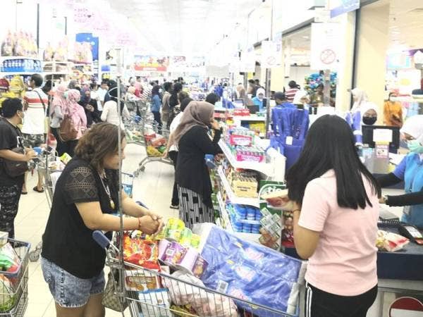 Orang ramai menunggu giliran untuk membayar selepas membeli barangan keperluan di sebuah pasar raya di sini malam tadi.