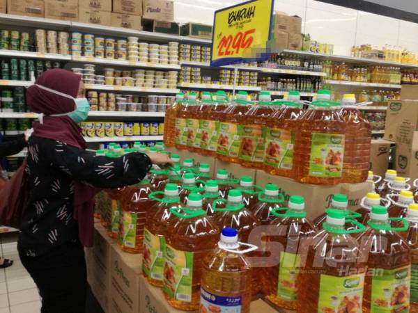 Seorang pengunjung melihat minyak botol yang penuh dirak pameran.