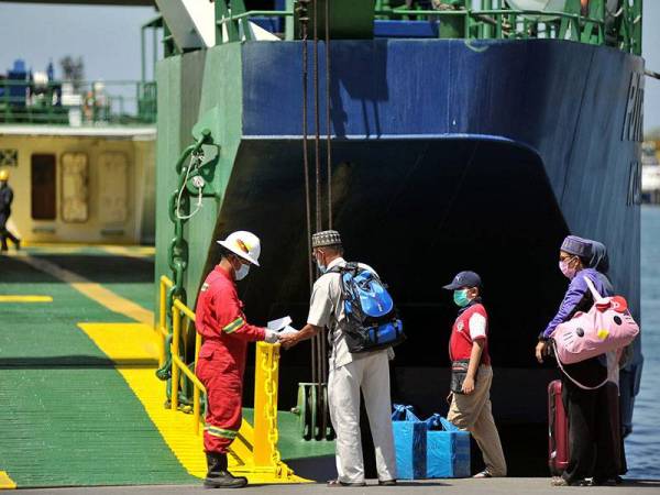 Kelihatan petugas operasi serta para penumpang feri Roll on-Roll Off (RORO) ke Menumbok Sabah memakai penutup hidung dan mulut sebagai langkah berjaga-jaga bagi mencegah penularan COVID-19 ketika tinjauan di Terminal Feri Antarabangsa Labuan hari ini. - Foto Bernama