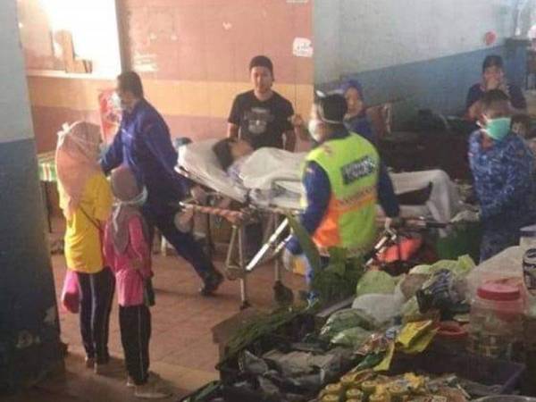 Foto yang dikongsi di Facebook menunjukkan petugas kecemasan yang memakai topeng muka mengusung seorang wanita di sebuah pasar awam di Sungai Besar.