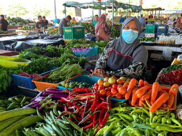Salah seorang peniaga mengenakan topeng muka untuk keselamatan dirinya.