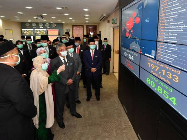 Al-Sultan Abdullah dan Tunku Azizah mendengar penerangan oleh Pengarah Kawalan Penyakit Bahagian Kawalan Penyakit Kementerian Kesihatan, Dr Norhayati Rusli (dua, kiri) mengenai situasi semasa Covid-19 yang dipaparkan di MyCPRC Dashboard ketika baginda berkenan melawat Pusat Kesiapsiagaan dan Respon Krisis (CPRC) Kebangsaan Kementerian Kesihatan (KKM) di Putrajaya. - Foto Bernama