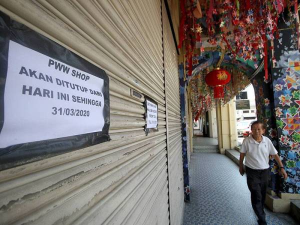 Seorang lelaki melalui deretan kedai di Jalan Market, Ipoh yang ditutup berikutan Perintah Kawalan Pergerakan di bawah Akta Pencegahan dan Pengawalan Penyakit Berjangkit 1988 dan Akta Polis 1967 mulai hari ini hingga 31 Mac sebagai langkah pencegahan penularan COVID-19. - Foto Bernama