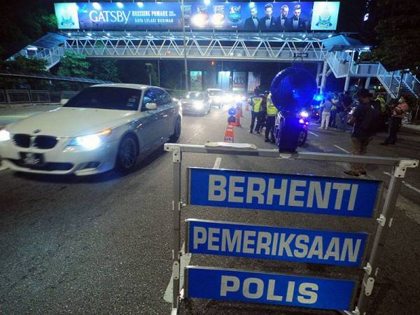 Anggota polis membuat sekatan jalan raya bagi menasihatkan rakyat Malaysia supaya mengambil serius tindakan kerajaan atas pelaksanaan Perintah Kawalan Pergerakan yang bermula hari ini sehingga 31 Mac sebagai langkah mengekang penularan jangkitan COVID-19 ketika Ops COVID-19 di Jalan Khoo Kai Kim, malam ini. - Foto Bernama