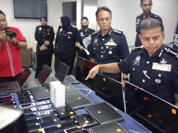 Ayob Khan Mydin Pichay (kanan) menunjukkan barang rampasan dalam satu kes penipuan selepas sidang media di IPK Johor, Johor Bahru hari ini.